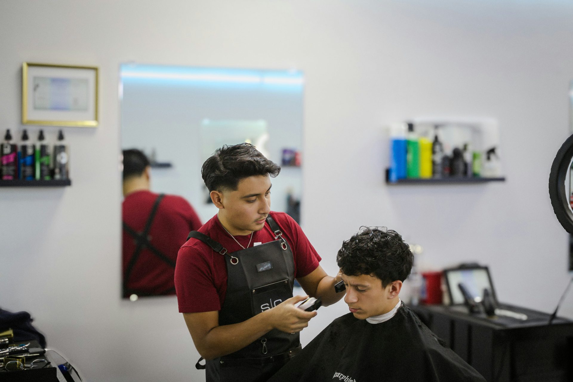 A man cutting another man's hair in a barber shop